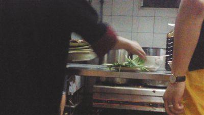 7月23日，漢麗軒烤肉超市昌平店，服務(wù)員將幾盤顧客剩菜（左手中疊在一起的是幾盤肉，其右手正整理韭菜）端回后廚，進(jìn)行整理后準(zhǔn)備再送往餐廳自助取餐區(qū)供顧客食用。